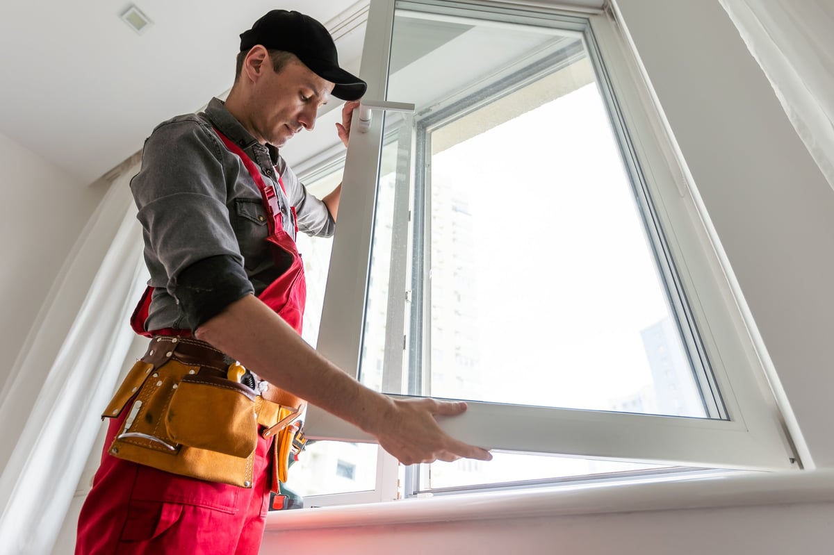 Worker installing a new window into an opening
