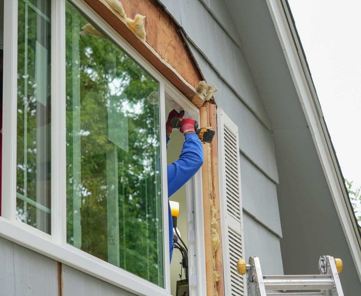 Contractor working on replacing a window on a house