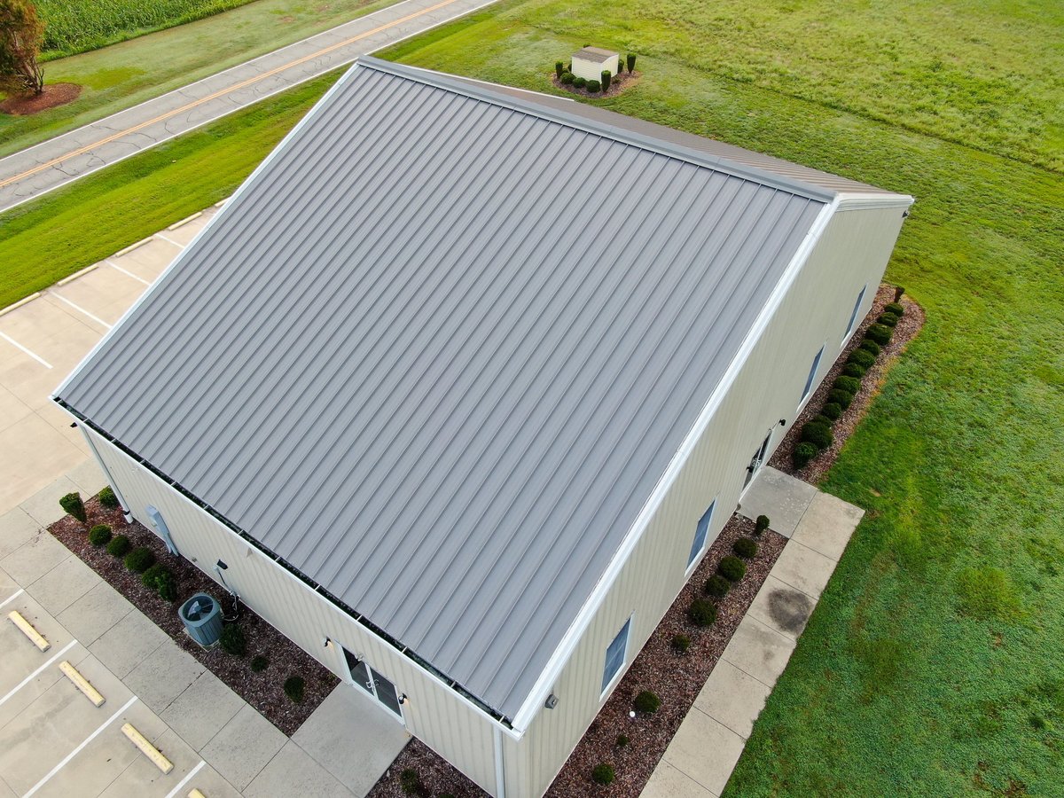 Commercial building with a new gray standing seam metal roof, seen from above